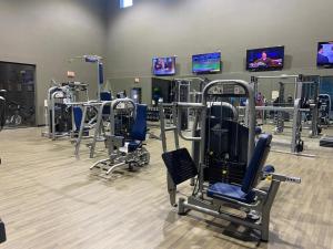 a gym with a row of tread machines and televisions at Spacious Apartments in The Woodlands, TX in The Woodlands