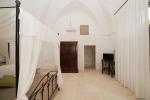 a bedroom with a bed and a table in a room at Casa Frea Dimora Storica in Martano +59 photos