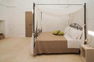 ein Schlafzimmer mit einem Himmelbett und grünen Kissen in der Unterkunft Casa Frea Dimora Storica in Martano