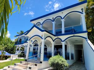 a large white building with blue accents at casaenjoysamana in Los Naranjos