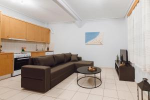 a living room with a couch and a table at THALASSA ALMYROS APARTMENTS in Almirón