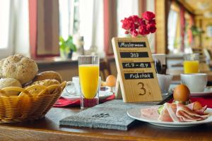 una mesa con alimentos para el desayuno y zumo de naranja en ella en Natur- und Wanderhotel am Steinbachtal, en Bad Kötzting