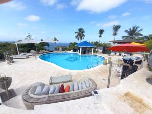 a pool with chairs and umbrellas and a table at casaenjoysamana in Los Naranjos