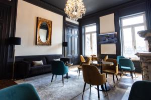 a living room with a chandelier and a table and chairs at Petit-Roannay in Stavelot