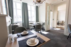 a dining room with a table and chairs and windows at Petit-Roannay in Stavelot