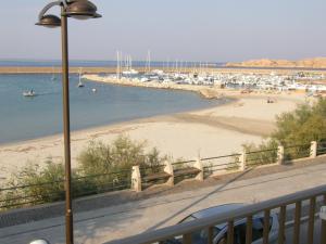 a view of a beach with boats in the water at Isola Rossa Appartamenti Superior in Isola Rossa