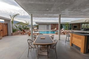 une terrasse avec une table, des chaises et une piscine dans l'établissement VILLA ALBA ROSULA, à Ajaccio
