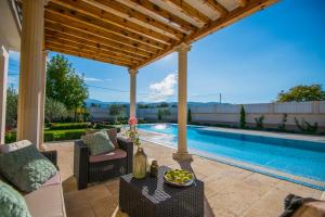 a backyard patio with a pool and a pergola at Holiday Home Petra in Donji Proložac