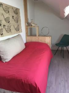 een slaapkamer met een rood bed en een groene stoel bij L' Huis-au-Tilleul in Quarré-les-Tombes