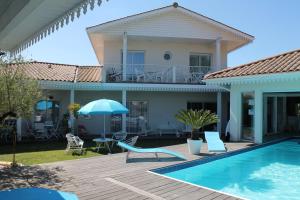 a villa with a swimming pool and a house at Aresia in Arès