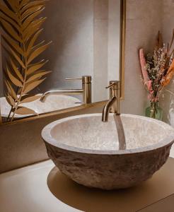 a bathroom with a stone sink and a mirror at Portomar Apartments in Portocolom