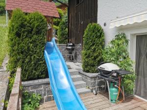a blue slide in front of a house with a grill at Schwendi Maison in Mels