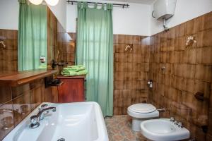 a bathroom with a sink and a toilet and a tub at Appartamento Piano terra in Sarroch +16 photos