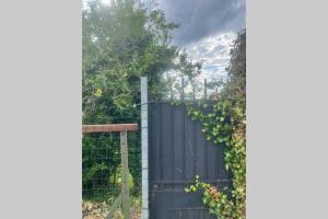 une clôture noire avec un portail noir avec des vignes dans l'établissement Apt 35 m2 Baignoire Balnéo terrasse privée, à Amfreville-la-Mi-Voie