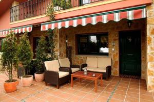 un patio con divani e tavolo e un edificio di Villa Brandán - Villa con piscina privada para 12p a Villaviciosa