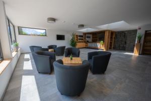 a waiting room with chairs and a wooden table at Residence Garni Melcherhof in Racines