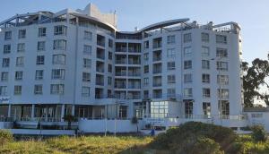 a white building on the side of a hill at Tranquil Impulse on Strand in Cape Town