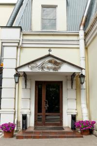 鄂木斯克的住宿－萊蒙托夫酒店，白色建筑的前门,花紫色