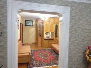 a doorway into a living room with a rug at Jordhani's House in Korçë
