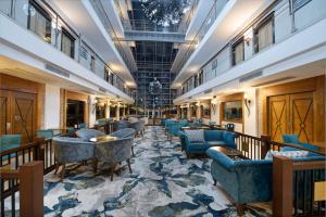 a hotel lobby with blue chairs and tables at Sealife Family Resort Hotel in Antalya