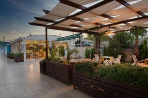 a patio with tables and chairs under a pergola at Sealife Family Resort Hotel in Antalya