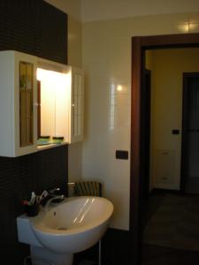 La salle de bains est pourvue d'un lavabo blanc et d'un miroir. dans l'établissement Casa Vacanze Montesilvano, à Montesilvano