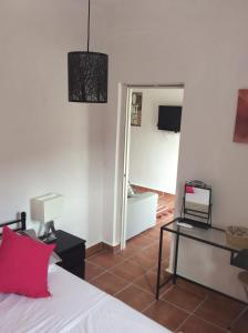 1 dormitorio con cama, mesa y espejo en Amandolas, en Casarabonela