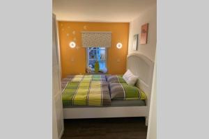 um quarto com uma cama com um cobertor verde e amarelo em Smart Home - Die etwas andere Ferienwohnung! em Brandenburg an der Havel