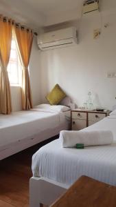 a room with three beds and a window at Easy Hostels in Panaji