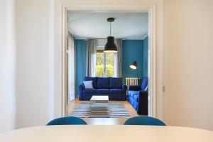 a living room with blue chairs and a blue couch at Diana - By Impero House in Stresa