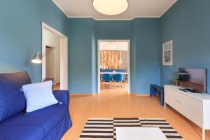 a living room with blue walls and a blue couch at Diana - By Impero House in Stresa