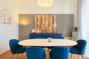een eetkamer met een tafel en blauwe stoelen bij Diana - By Impero House in Stresa