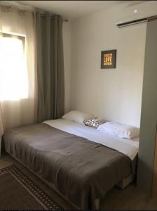 ein Bett in einem Schlafzimmer mit einer Uhr an der Wand in der Unterkunft Candy apartment central location Bečići in Becici