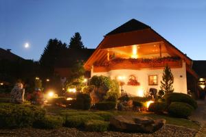 een huis met een groep mensen die 's nachts buiten zitten bij Haus Sonnenschein in Gößweinstein