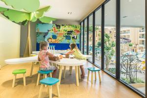 zwei Kinder, die an einem Tisch in einer Kindergarten-Cafeteria sitzen in der Unterkunft Pamookkoo in Kata Beach