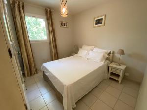 a bedroom with a white bed and a window at Le Gîte du Diamant Noir in Aups +17 photos