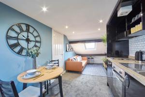 a kitchen and living room with a table and a clock at Host & Stay - The Loft in Whitby