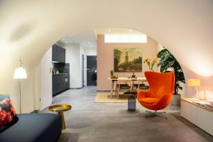 een woonkamer met een oranje stoel en een tafel bij LOFT 188 Luxury Apartment Hotel in Utrecht