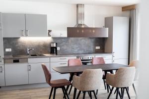 a kitchen with a dining room table and chairs at Haus Fellhorn - Ferienwohnungen in Riezlern +29 photos