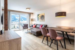a living room with a table and a couch at Haus Fellhorn - Ferienwohnungen in Riezlern
