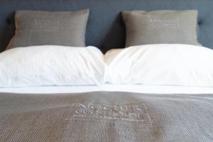 a bed with two pillows on top of it at KRACHER Guesthouse No 7 - inklusive Pool in Illmitz +12 photos