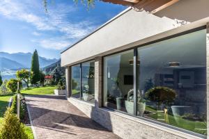 a house with large windows with mountains in the background at Residence Garni Melcherhof in Racines