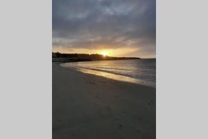 un tramonto sulla spiaggia con il sole in lontananza di La Casita de Galaila a Costa Calma