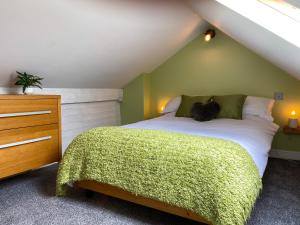 ein Schlafzimmer mit einem Bett mit einer grünen Wand in der Unterkunft 'Llandudno Central' - 2 Bed Luxury Flat, Close to Town and Beaches in Llandudno