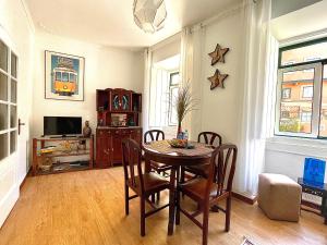 een eetkamer met een tafel en stoelen en een tv bij The Spot in Alfama in Lissabon