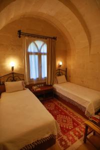two beds in a room with a window at Hotel Surban - Special Category in Ürgüp