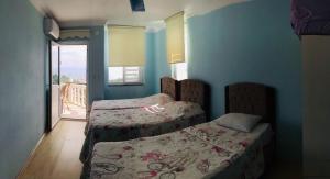 1 Schlafzimmer mit 2 Betten und einem Balkon in der Unterkunft Sadik Villa (Sea View 4 Bedrooms and 4 Bathrooms) in Trabzon