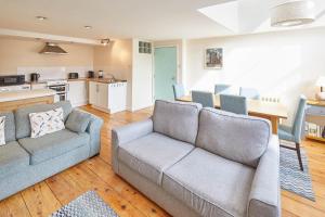 a living room with two couches and a kitchen at Mary Lyth - Whitby West Cliff with parking in Whitby