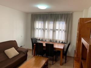 sala de estar con mesa, sillas y sofá en Segeda Apartamentos, en Calatayud