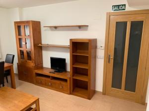 a living room with wooden furniture and a tv at Segeda Apartamentos in Calatayud